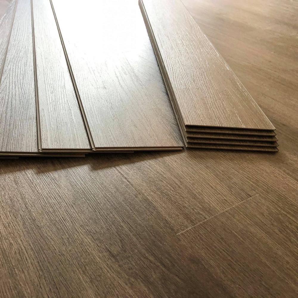 Laminate planks stacked ready to lay on a partially installed floor mid-installation